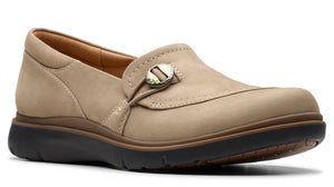 Beige slip-on shoe with a button-like adornment.