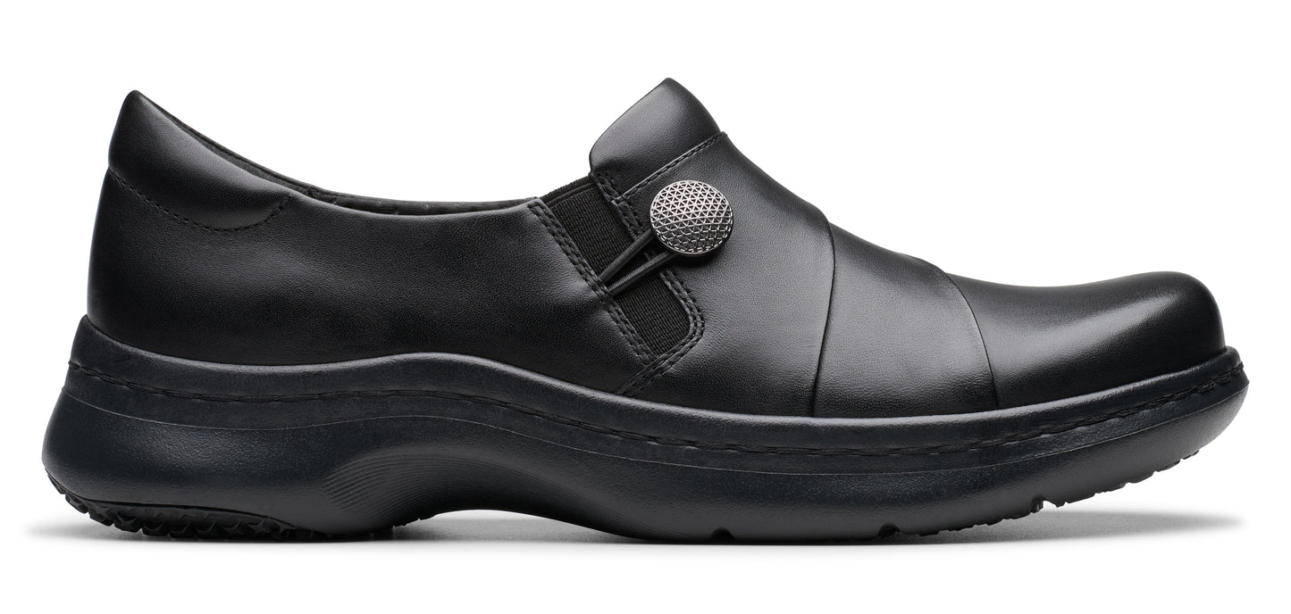 Black slip-on shoe with a round, textured button detail.