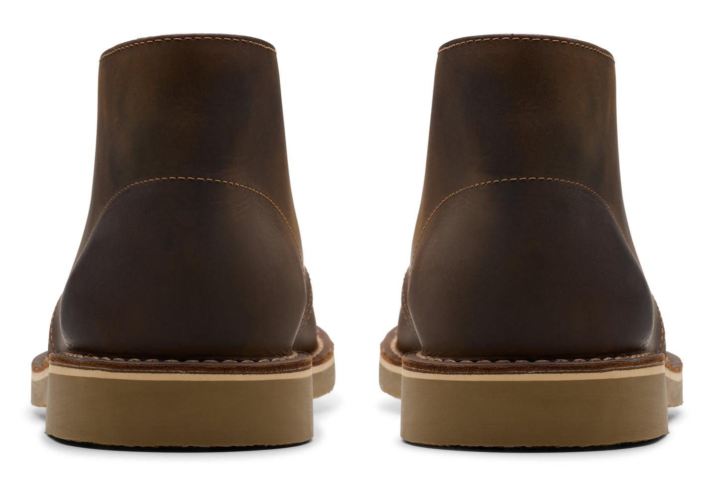 Back view of two brown suede chukka boots showing light brown soles and minimal stitching.