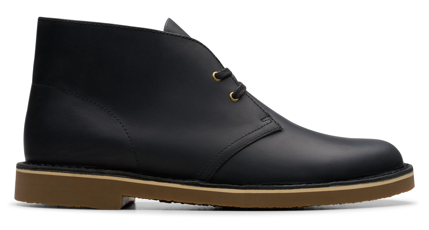 Black leather chukka boot with a tan sole and two eyelets.