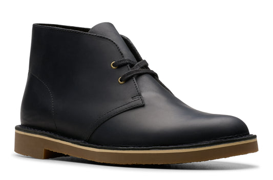 Black leather chukka boot with laces and a low, tan-colored sole.