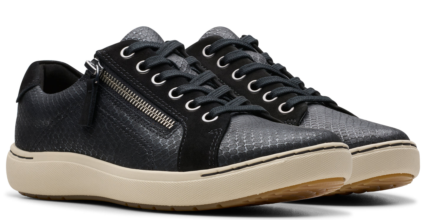 A pair of low-top sneakers with black laces, side zipper, and a tan sole.