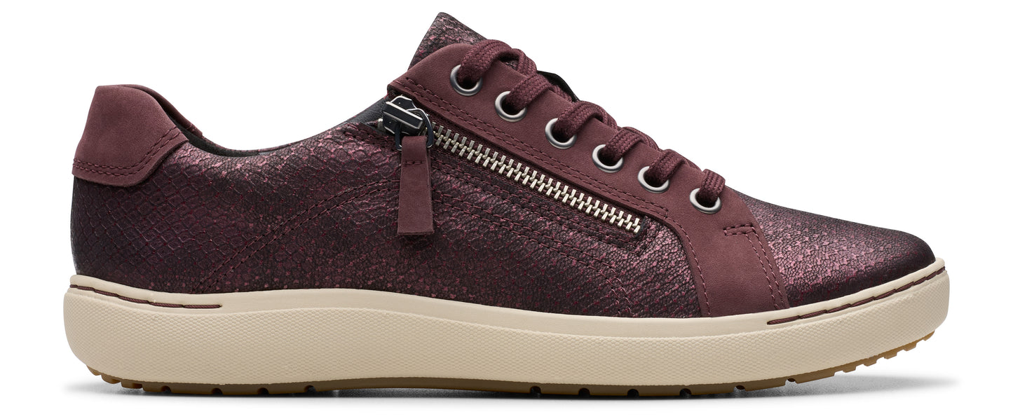 A maroon colored sneaker with a side zipper and beige rubber sole.