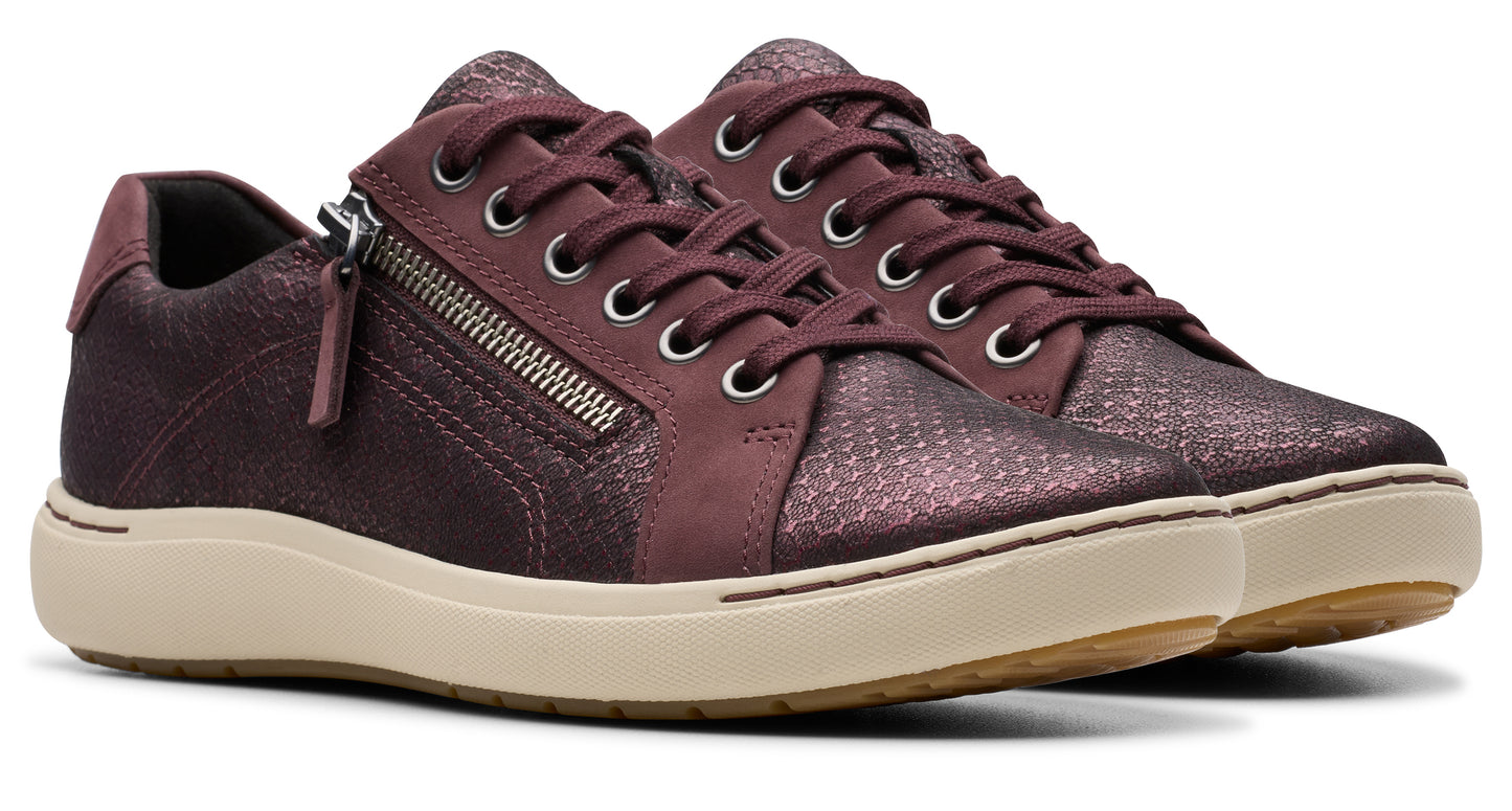 Maroon sneaker with a side zipper on a cream sole