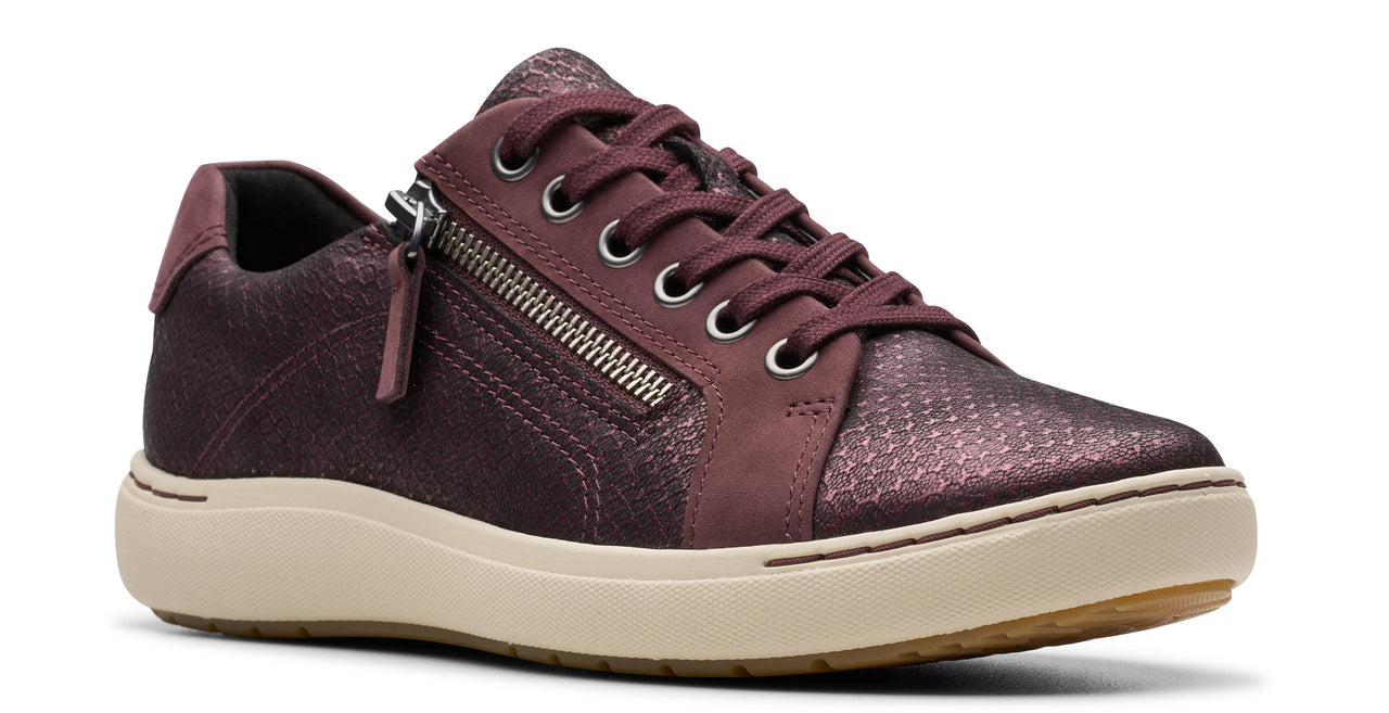 Low-top sneaker in iridescent, dark-red snakeskin-like material with laces and a side zipper on a cream sole.