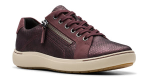 Low-top sneaker in iridescent, dark-red snakeskin-like material with laces and a side zipper on a cream sole.