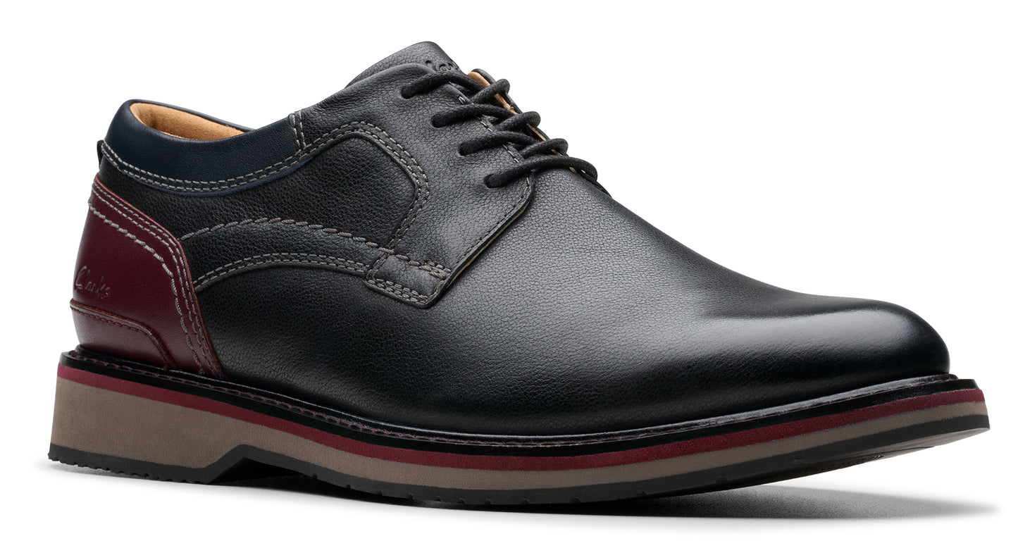 Black leather dress shoe with red and blue accents and lace-up closure.