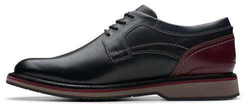 A black leather dress shoe with a burgundy accent.