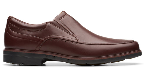 A dark brown, leather slip-on dress shoe with a black sole.