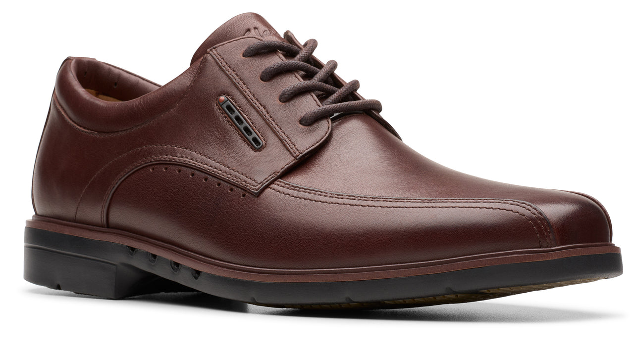 Brown leather dress shoe with laces and black sole.
