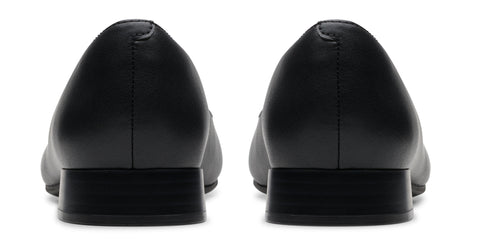 Back view of a pair of black, low-heeled dress shoes.