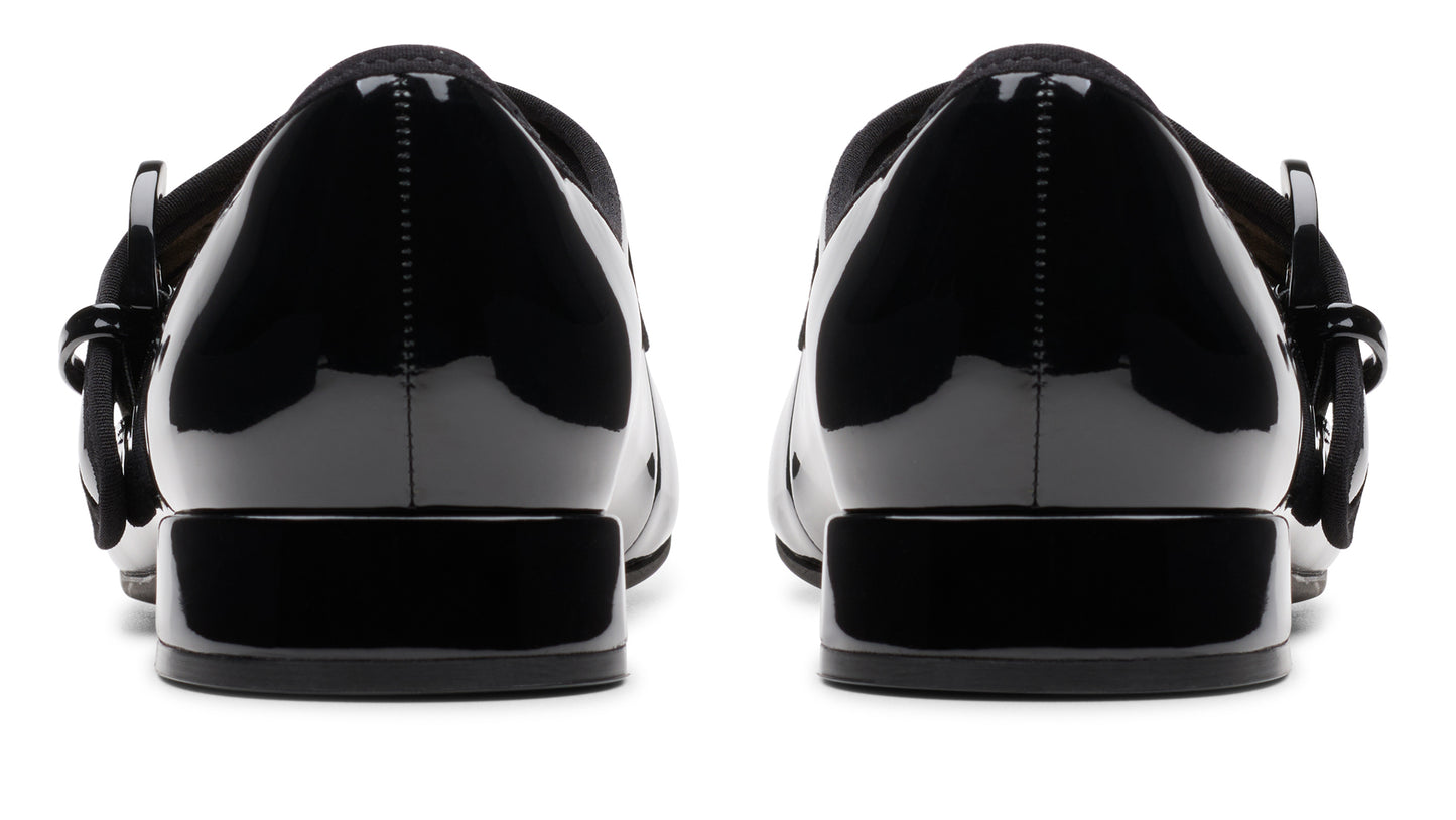 Back view of glossy black patent leather Mary Jane shoes with block heel and buckle.