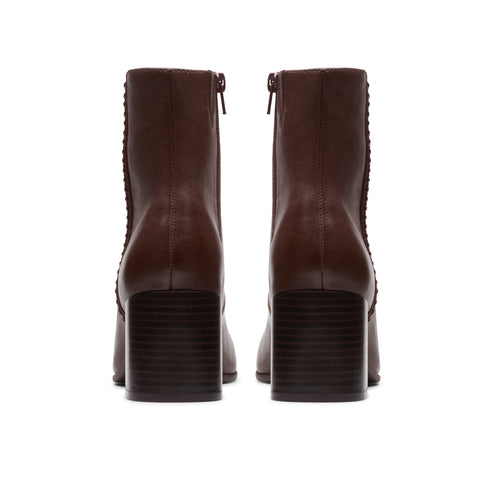Rear view of two dark brown ankle boots with side zipper and block heel.