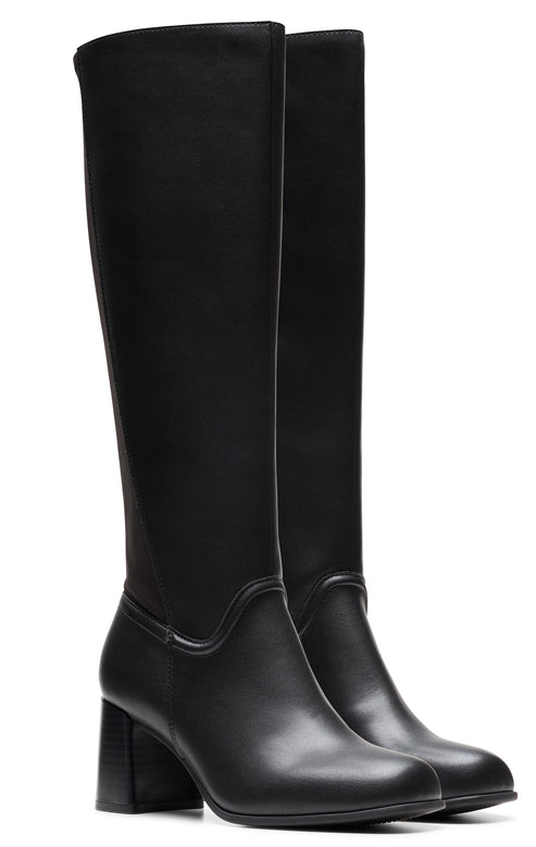 A pair of black knee high heeled boots.