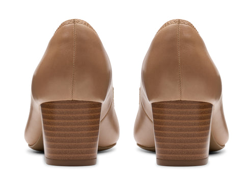 Pair of beige leather heeled pumps with block heels.