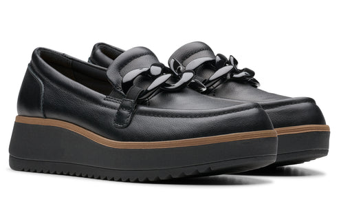 Pair of black, slip-on loafers with a chunky chain detail on the vamp and a thick, black platform sole with a brown accent stripe.