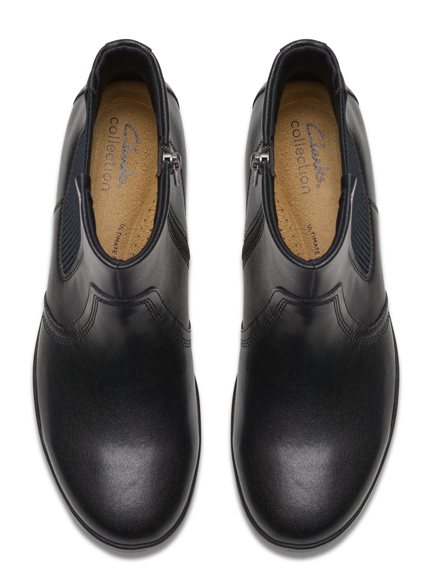 Top-down view of a pair of black, low-heeled, ankle boots with side zippers and elastic side panels; the insole reads "clarks collection".