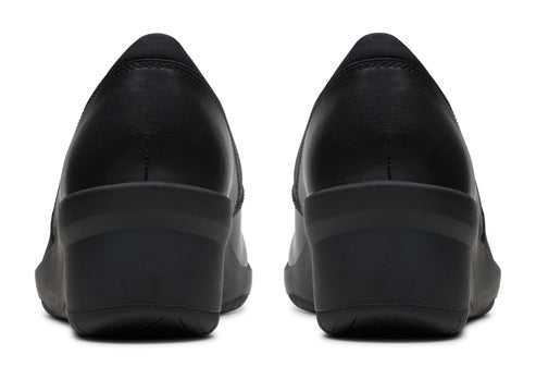 Pair of black leather wedge heel pumps from the back.