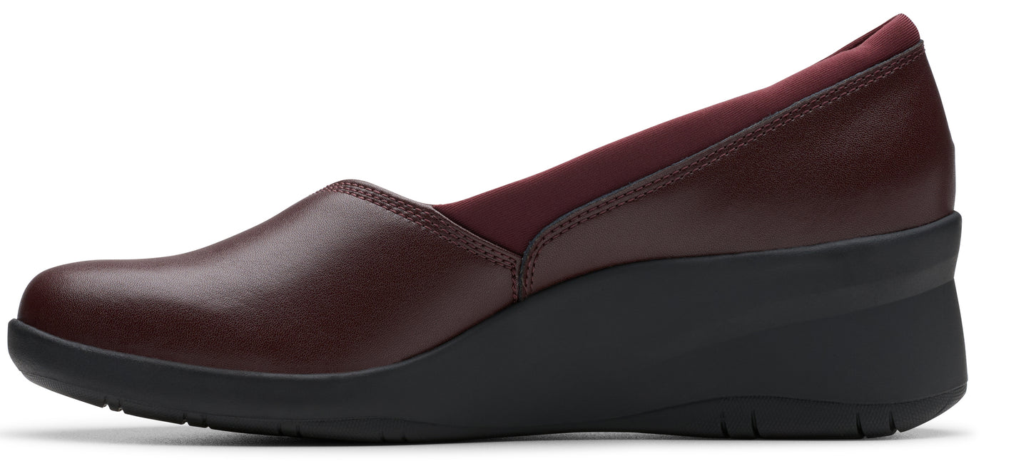 A slip-on shoe with a wedge heel in burgundy.
