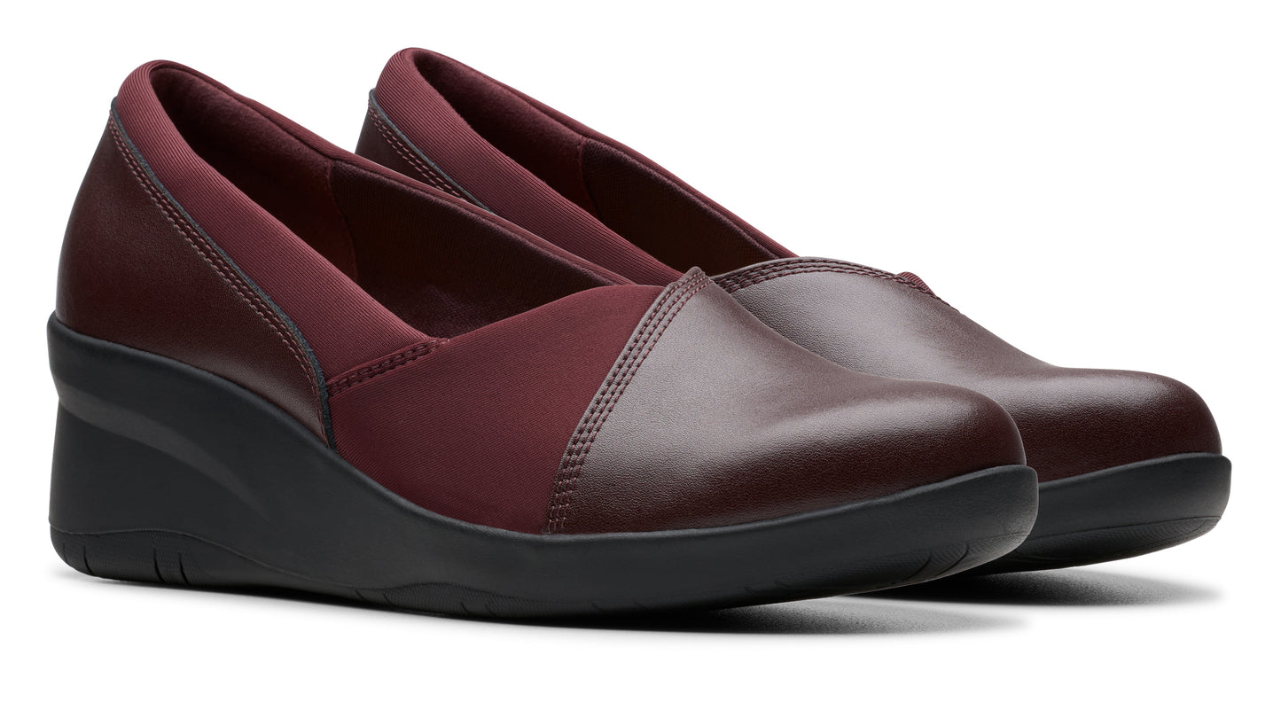 Pair of maroon wedge heel shoes with elastic inserts.