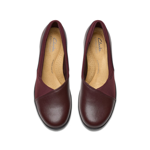 Pair of rounded-toe burgundy leather flats with fabric v-shaped panels.
