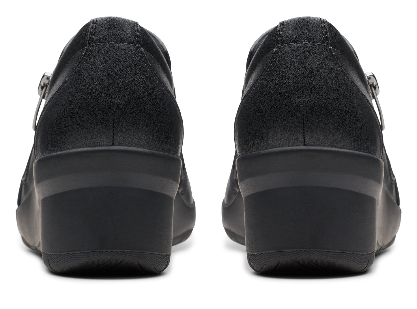 Pair of black leather wedge shoes, seen from the back, with side zipper.