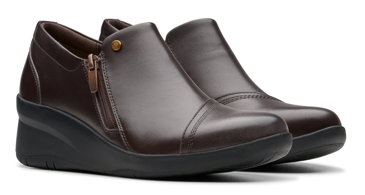 Pair of dark brown wedge heeled shoes with a side zipper and rounded toe.