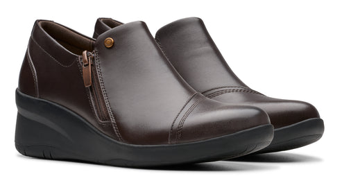Pair of dark brown wedge heeled shoes with a side zipper and rounded toe.