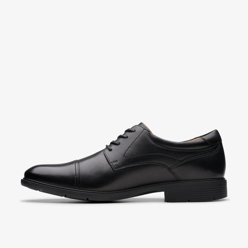 Black leather cap-toe dress shoe with lace-up closure.