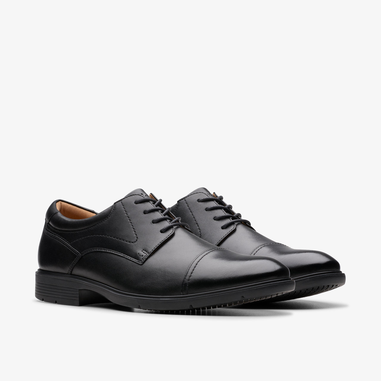A pair of black leather cap toe dress shoes with black laces.