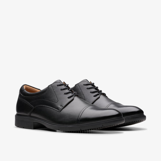 A pair of black leather cap toe dress shoes with black laces.