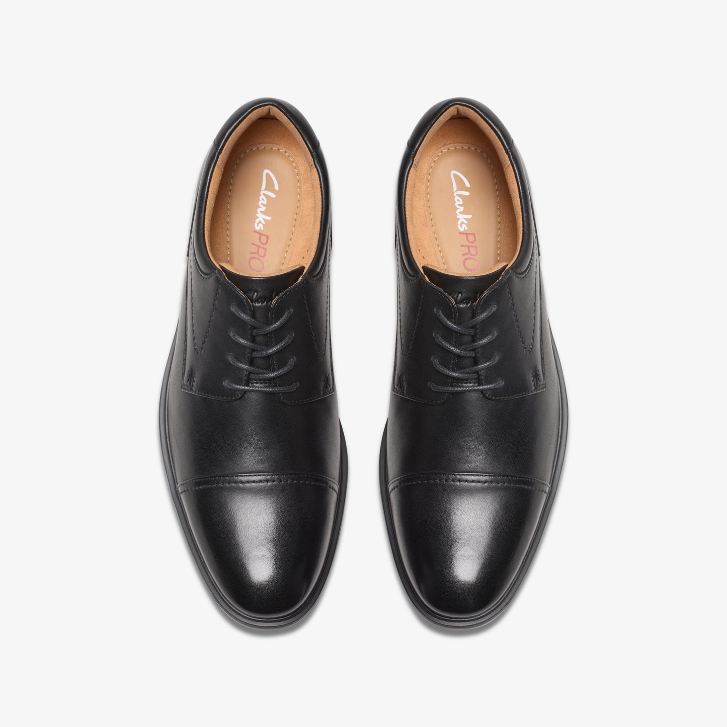 Pair of black leather cap-toe dress shoes with laces, viewed from above.