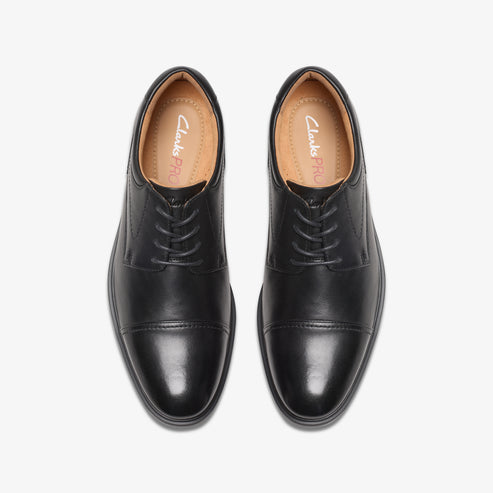Pair of black leather cap-toe dress shoes with laces, viewed from above.
