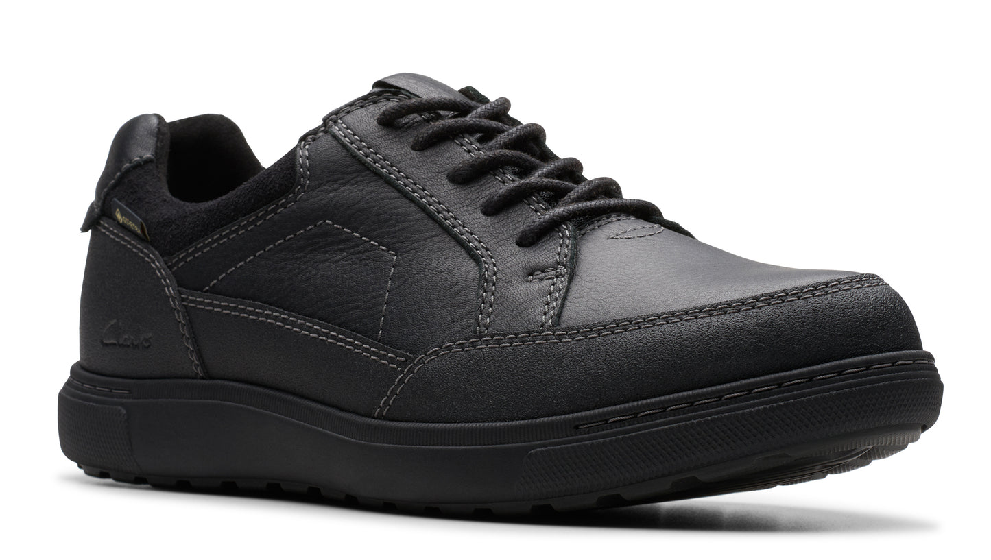 A black leather casual shoe with a low profile and lace-up closure.