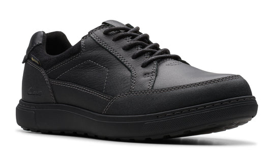 A black leather casual shoe with a low profile and lace-up closure.