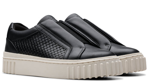 Pair of black slip-on sneakers with textured side panel and thick, light-colored sole.