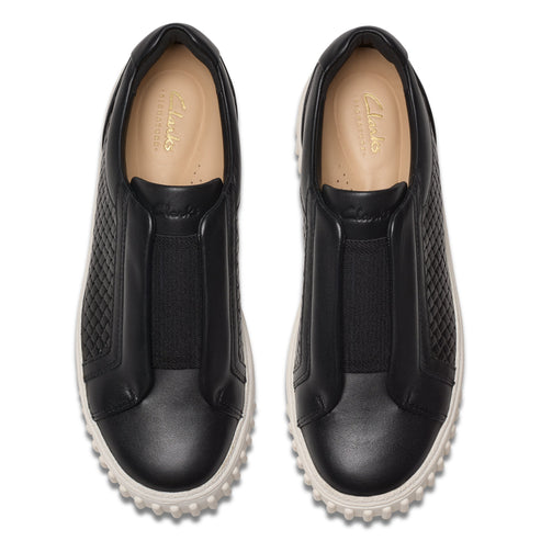 Pair of black leather slip-on shoes with textured quilted side panels and white soles.