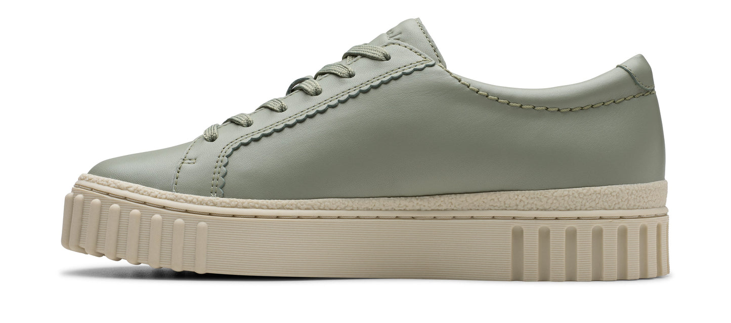 A side-view shot of a light-green leather low-top sneaker with a thick, beige sole and lace-up closure.