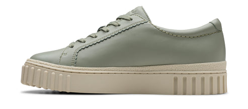 A side-view shot of a light-green leather low-top sneaker with a thick, beige sole and lace-up closure.