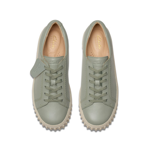 Overhead shot of a pair of sage green leather sneakers with laces and a ridged sole.