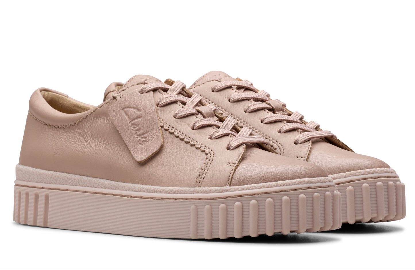 Pair of beige leather sneakers with platform ridged soles and lace-up closure.