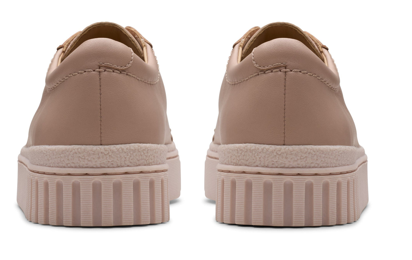 Pair of flat, pink sneakers with thick soles, rear view.