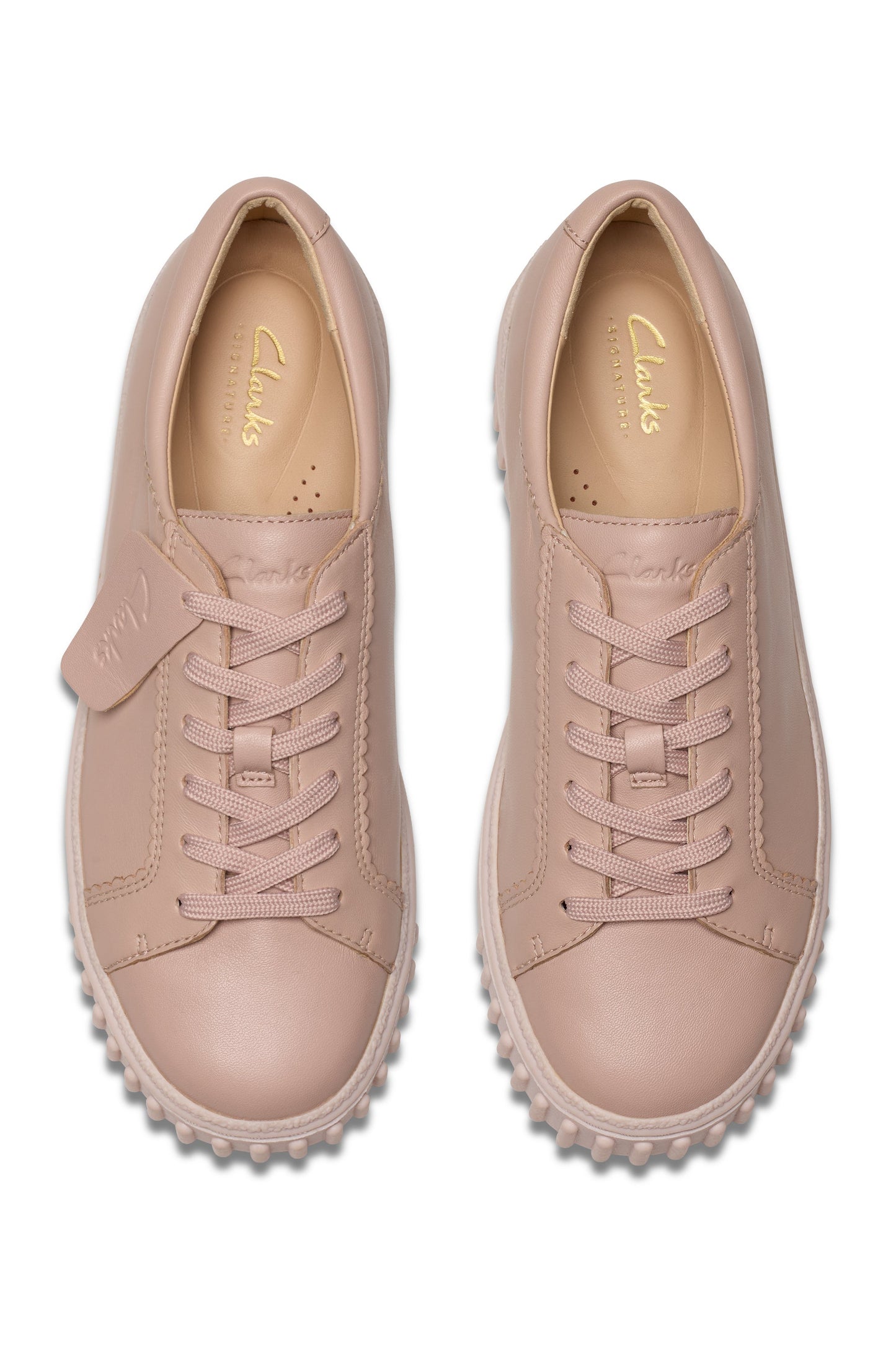 Two pink leather sneakers with light pink laces, soles with textured edges, and insole text stating "Clarks".