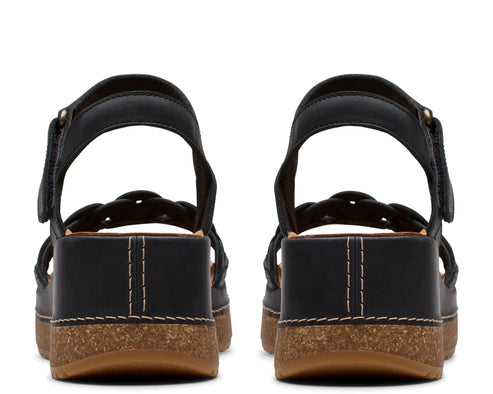 Back view of black platform sandals with braided straps and ankle strap with hook-and-loop fastener.