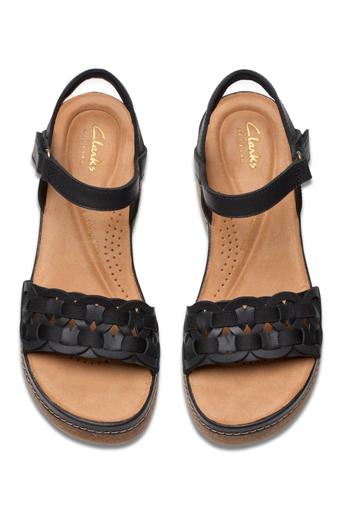 Pair of black sandals with a woven strap and ankle strap with logo on the inner sole.