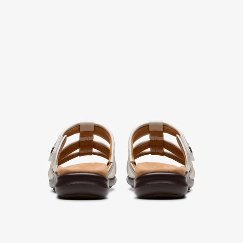 Pair of white strappy sandals with brown soles, viewed from the back.