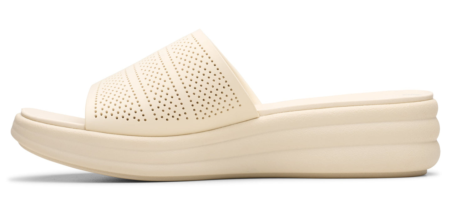 Beige wedge sandal with patterned perforations.