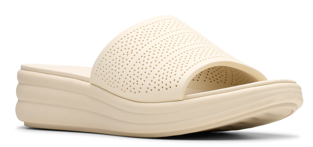 A women's beige slide sandal with a wedge sole and perforated details.