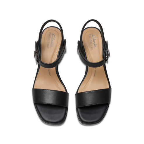 Overhead studio shot of a pair of black leather heeled sandals with straps and silver buckles.