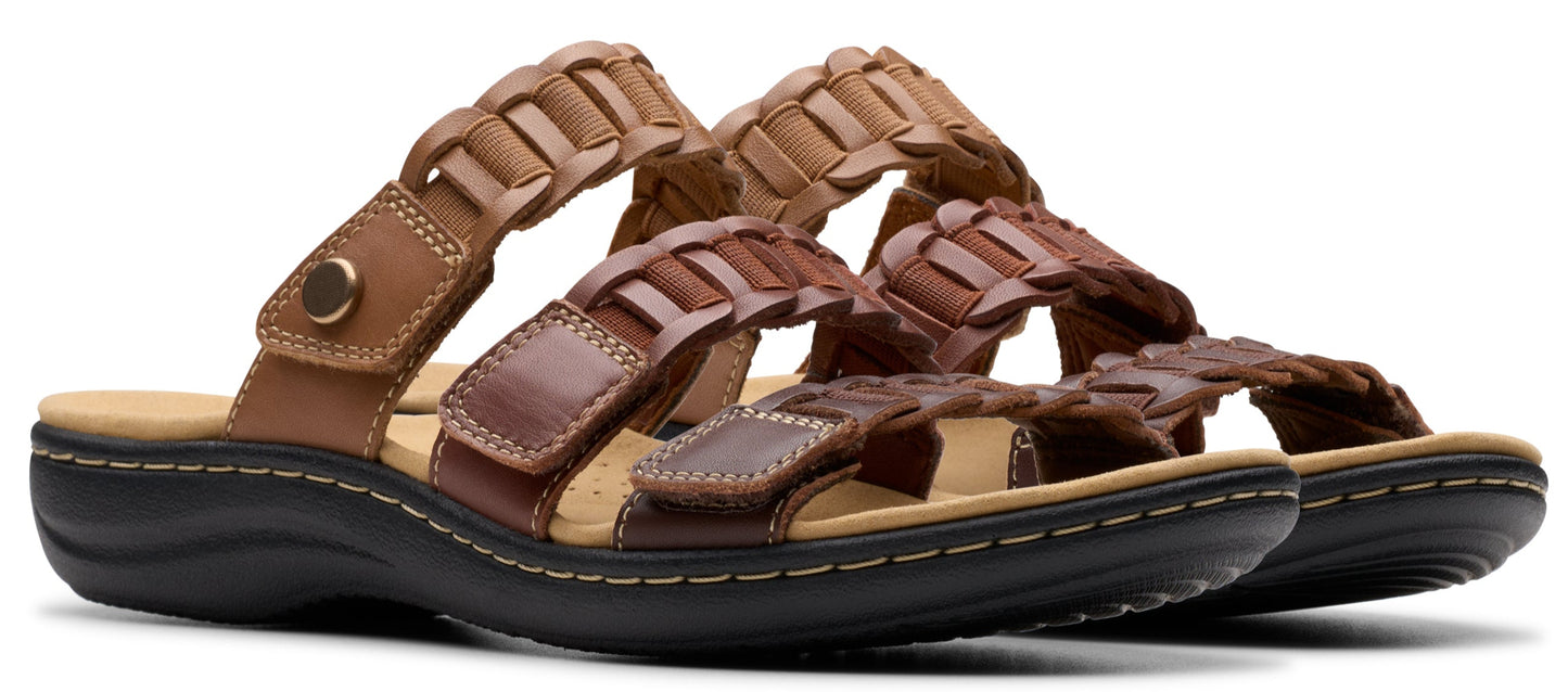 A pair of leather brown sandals with a black sole.